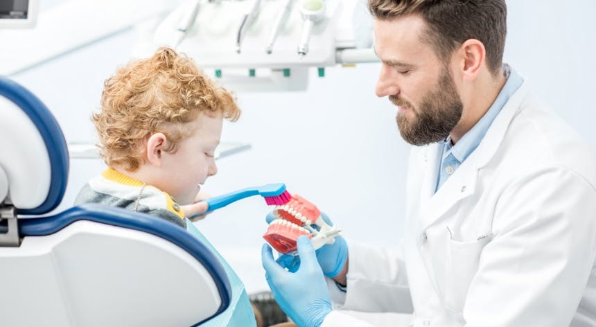 dentist-showing-boy-how-brush-teeth